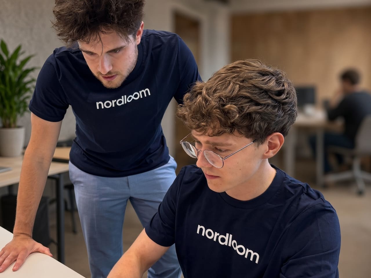 Zwei Mitarbeiter von Nordloom klären eine Frage gemeinsam am Bildschirm